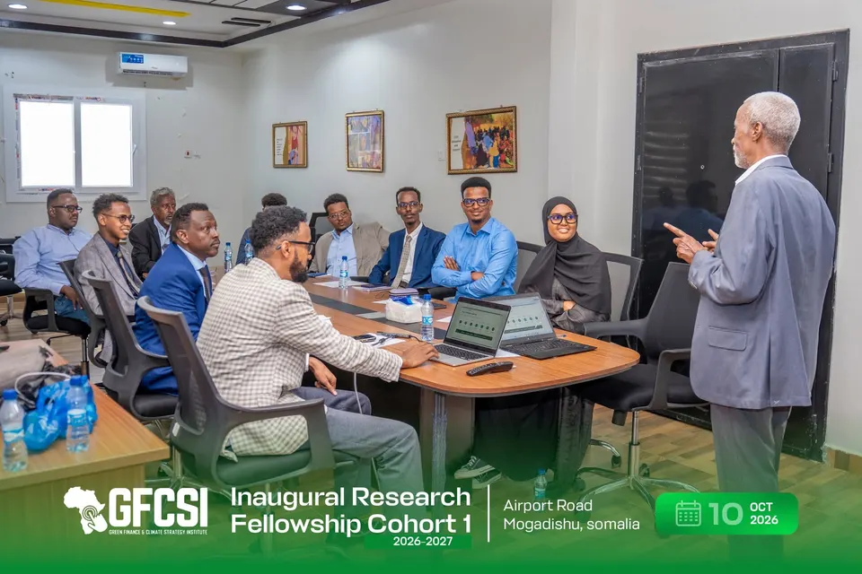 A facilitator standing and addressing participants seated around the conference table.