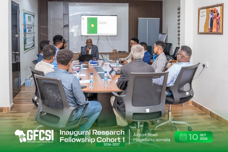 Participants seated around a conference table during the induction session, with a presentation titled 'From Induction to Graduation' on the screen.
